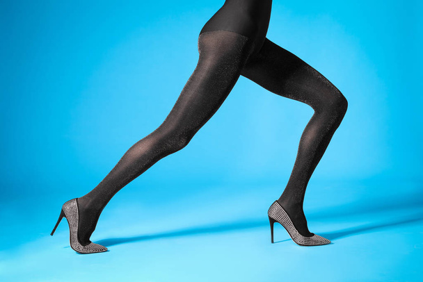 Woman wearing black tights and stylish shoes on blue background, closeup of legs - Photo, Image