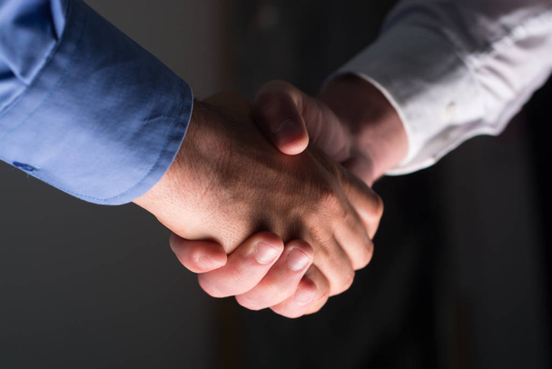 Two Businessman Handshake Handshaking between darkness and light - Photo, Image