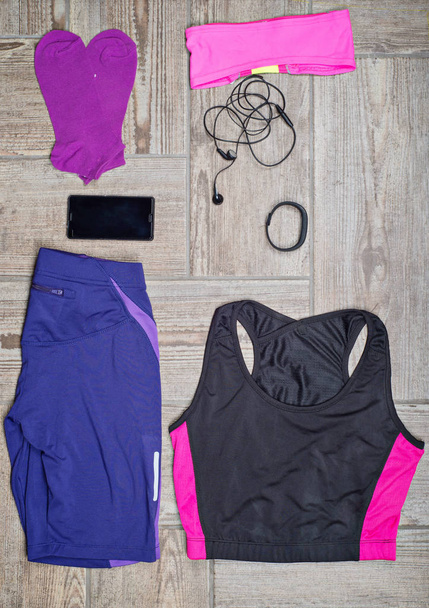 Flat lay shot of woman's sport accessories. Leggins, sneakers, earphones, phone and top. Ready to do some workout. - Foto, Imagem
