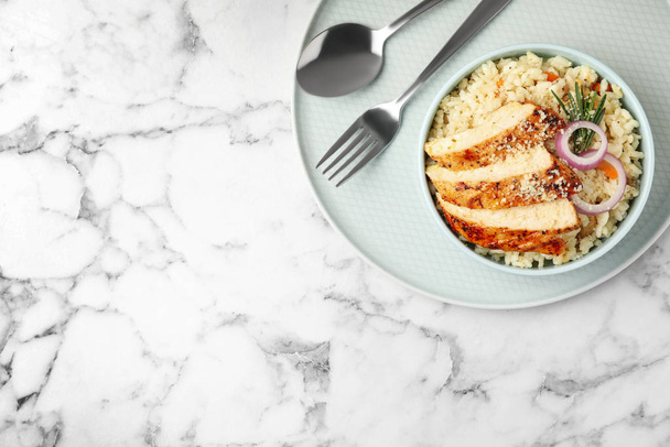 Delicious chicken risotto served on white marble table, top view. Space for text - Foto, Imagen
