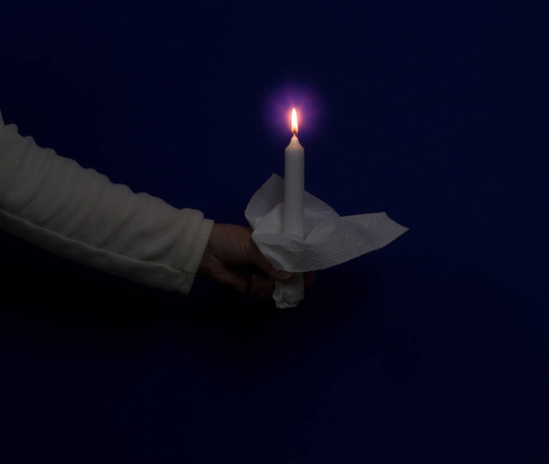 eine Hand hält eine brennende Kerze. - Foto, Bild