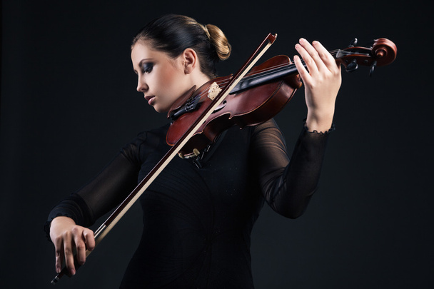 Beautiful young woman playing violin over black - Fotoğraf, Görsel