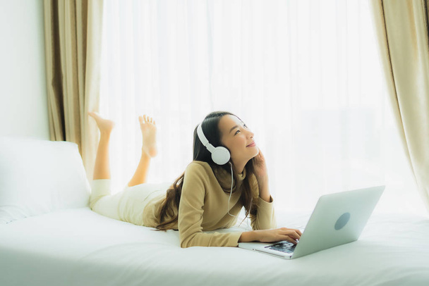 Fiatal ázsiai nő használ laptop fejhallgató zenét hallgatni - Fotó, kép