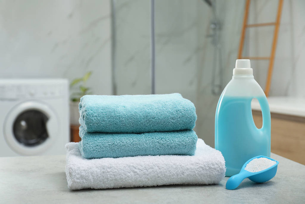 Clean towels and detergents on table in laundry room - Foto, Imagem