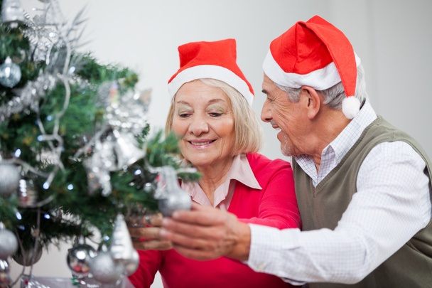 Senior Couple Decorating Christmas Tree - Foto, afbeelding