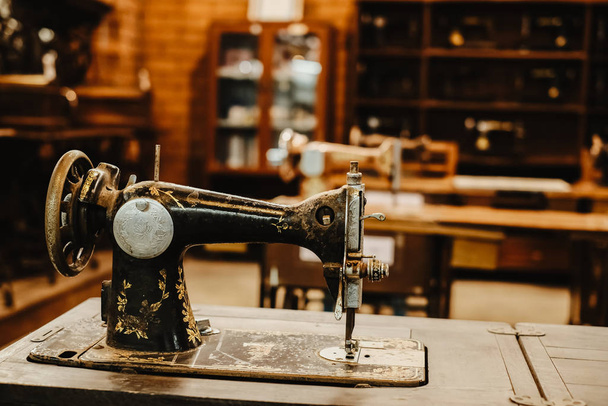 máquina de coser vintage en el lugar de trabajo de la fábrica de prendas. tecnología retro. tono de color vintage
. - Foto, imagen