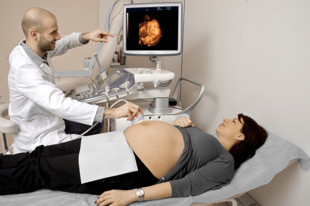 Беременная женщина получает ультразвук от врача
 - Фото, изображение