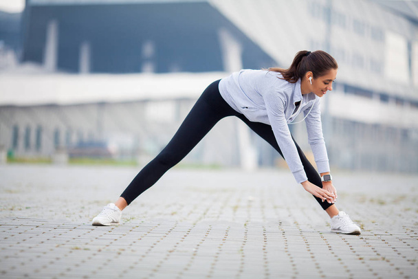 Mulher fitness fazendo exercício em pé em um estádio de fundo
 - Foto, Imagem