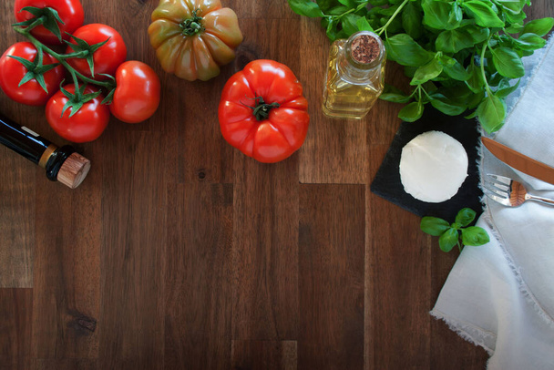 Fresh ingredients for an italian caprese on a rustic wooden table - Fotoğraf, Görsel