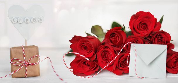 still life with a bouquet of red roses and a message on white background for valentines day - Foto, imagen