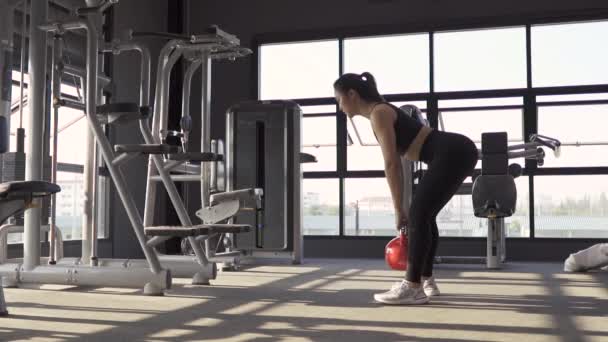 Vrouw oefening met kettlebell squat benen in fitnessruimte gezonde levensstijl spieropbouwer, atletische sport vrouw training uithoudingsvermogen sterke training. Hd Slow motion Beeldmateriaal cinematisch - Video