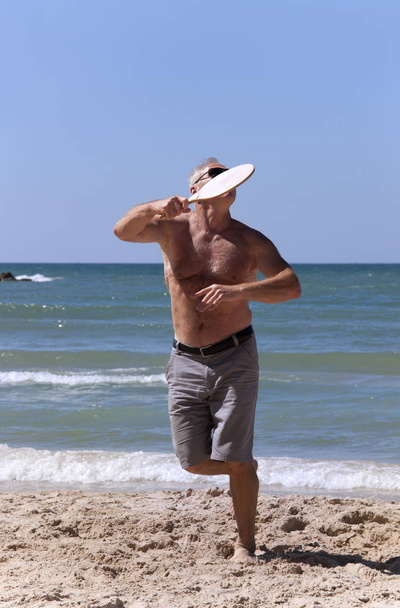 przystojny dorosły mężczyzna gra w tenisa na plaży - Zdjęcie, obraz