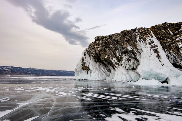 Cracked ice of frozen lake Baikal. Winter landscape. Travel concept. - Photo, image