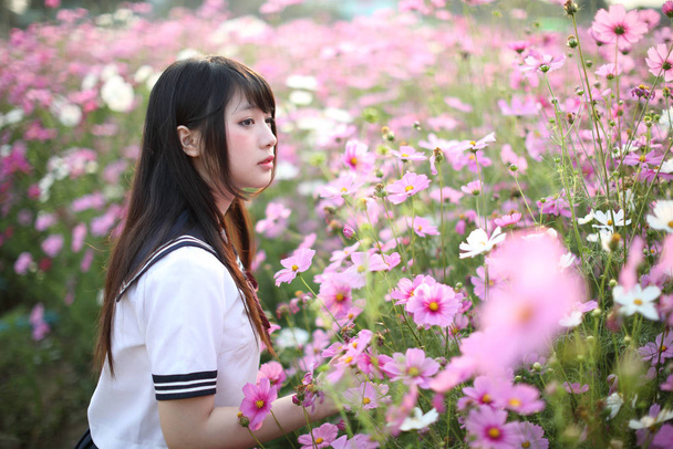 ピンクのコスモスの花で統一された日本の女子高生の肖像 - 写真・画像