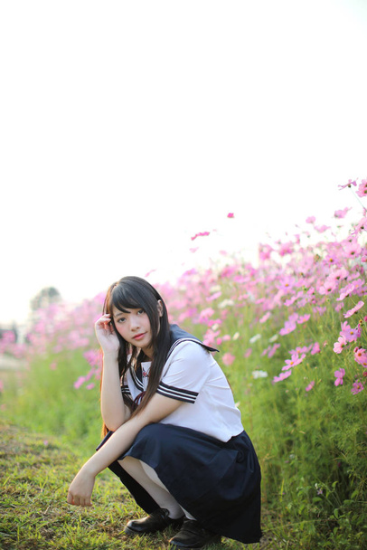 Πορτρέτο της ιαπωνικής στολή κορίτσι σχολείο με ροζ λουλούδι σύμπαν - Φωτογραφία, εικόνα