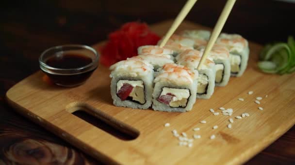świeże sushi rolki na stole ciemne tło sushi patyczki - Materiał filmowy, wideo