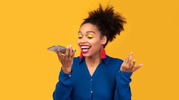 Feliz afro mulher usando assistente de voz no smartphone
 - Foto, Imagem