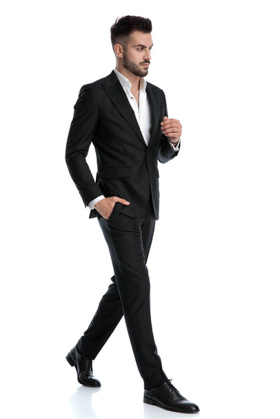 hombre de negocios caminando con la mano en el bolsillo mirando hacia otro lado pensativo
 - Foto, imagen