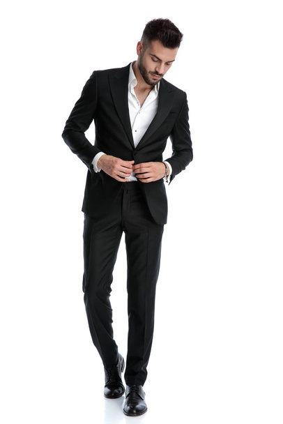 zakenman lopen met stijl en vaststelling jas terwijl op zoek d - Foto, afbeelding