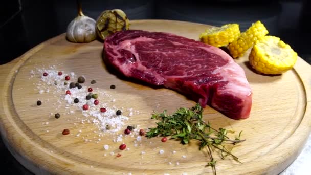 raw meat a large piece of beef chop on a cutting board with rosemary and spices  - Záběry, video