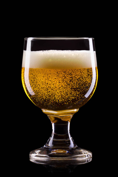 Frosty glass of light beer with foam isolated on a black background - Valokuva, kuva