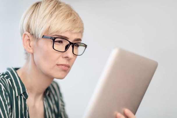 Lady In Eyeglasses Using Tablet Squinting Eyes Sitting Indoor - Zdjęcie, obraz