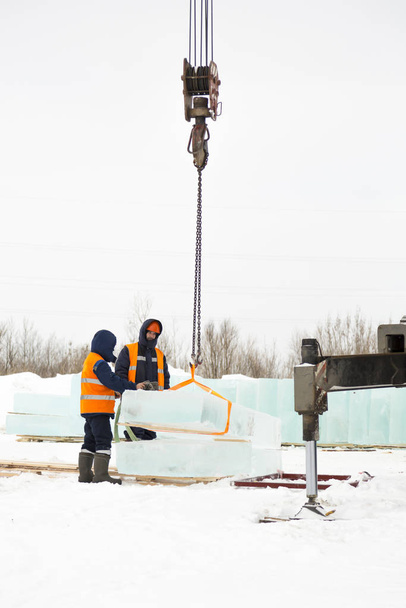 Slingers in special winter overalls for shipment of ice blocks - Photo, Image