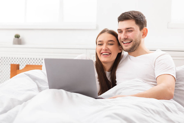Paar schaut Film auf Laptop zu Hause im Bett liegend - Foto, Bild