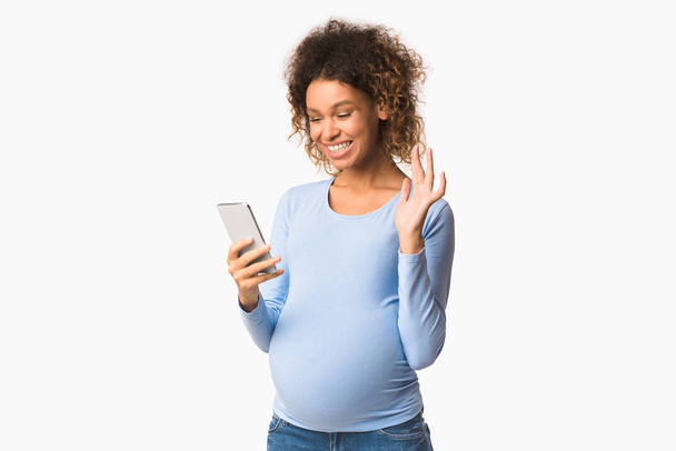 幸せな妊婦持っていますビデオ通話と手を振って - 写真・画像