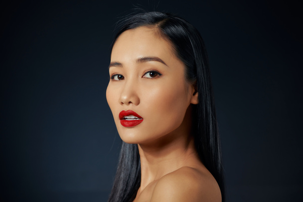 Азиатская красивая женщина с красной помадой изолированы на черном фоне. copyspace. - Фото, изображение