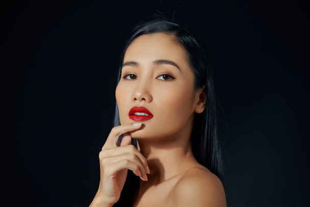 schöne junge Frau mit hellem Lippenstift auf schwarzem Hintergrund - Foto, Bild