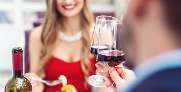 Ζευγάρι ψήσιμο με κόκκινο κρασί σε ρομαντικό εστιατόριο - Φωτογραφία, εικόνα