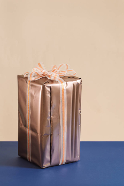 boîte cadeau avec ruban doré sur fond bleu
 - Photo, image