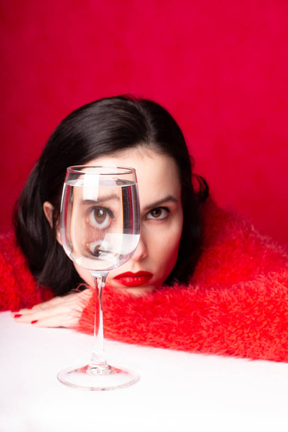 hermosa chica en rojo con un vaso de agua
 - Foto, Imagen