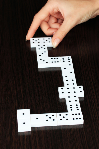 Hand playing domino on wooden background - Zdjęcie, obraz
