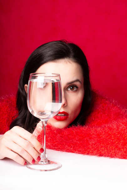 beautiful girl in red with a glass of water - Photo, image