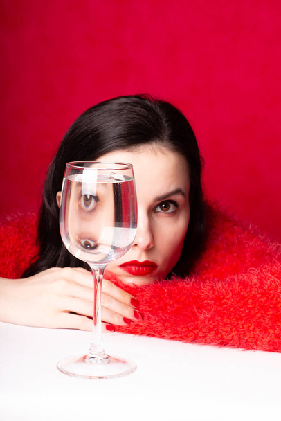 krásná dívka v červené se sklenicí vody - Fotografie, Obrázek
