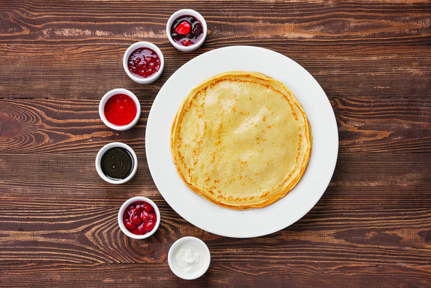 Top view of thin pancakes with assortment of jam and sauce - Photo, Image