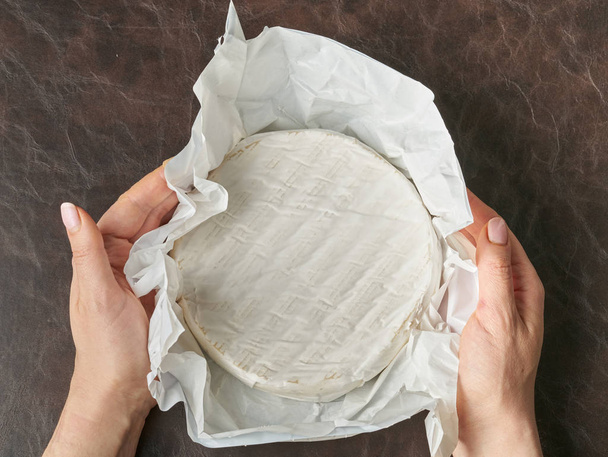 Camembert-Käse rund um den Frieden in Frauenhänden - Foto, Bild