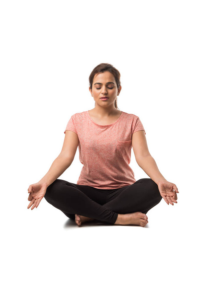 Hintli Kadın / Kız Yoga yaparken veya meditasyon yaparken veya Dhyan yaparken, beyaz arka planda tek başına otururken - Fotoğraf, Görsel