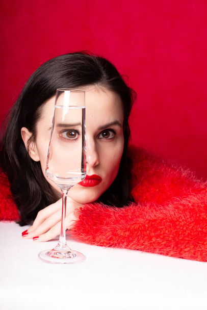 beautiful girl in red with a glass of water - Фото, зображення