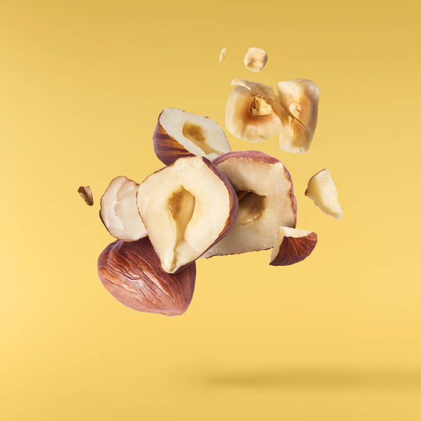Hazelnuts crushed into pieces, frozen in the ai - Photo, Image
