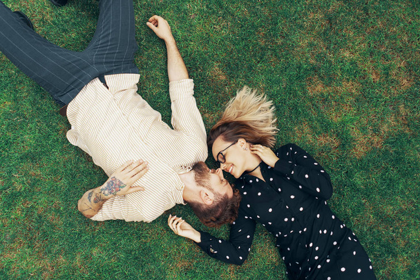 草の上に横たわる恋カップル - 写真・画像