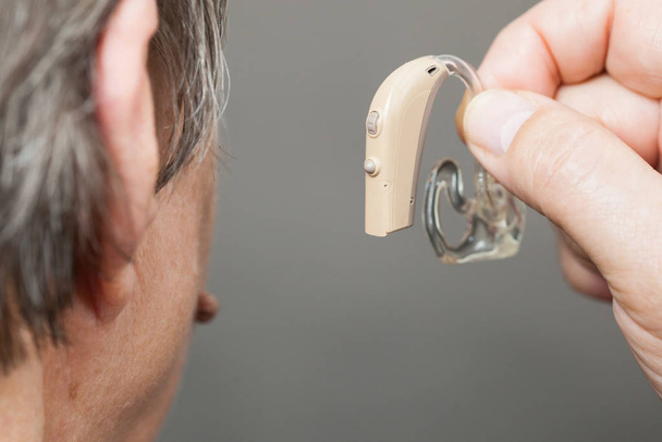 Closeup senior woman using hearing aid - Foto, Imagen