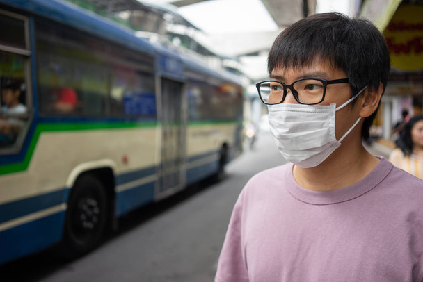 Knappe man met gezichtsmasker beschermt filter tegen luchtvervuiling - Foto, afbeelding