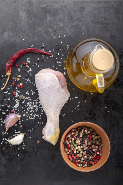 raw chicken leg with spices - Foto, afbeelding
