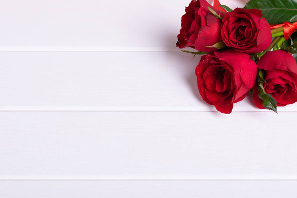 Κόκκινο τριαντάφυλλο μπουκέτο σε λευκό φόντο ξύλο - Φωτογραφία, εικόνα