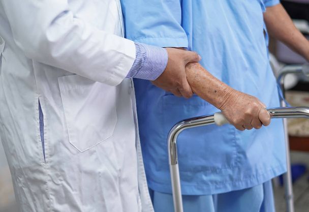 Arts helpen Aziatische senior of oudere oude dame patiënt lopen met walker op verpleegkundige ziekenhuis afdeling: gezonde sterke medische concept - Foto, afbeelding