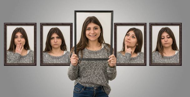 mooi meisje toont diverse gezichtsuitdrukkingen met een foto frame in haar handen - Foto, afbeelding