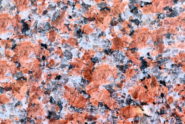 Granite texture of the material is pink tone, the relief of natural stone with its bizarre outlines. - Photo, Image